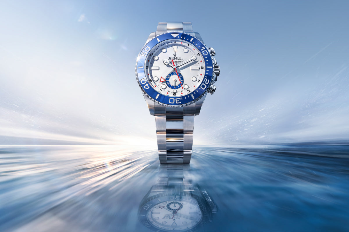 Luxury watch with blue and silver design on a reflective surface with a blurred background