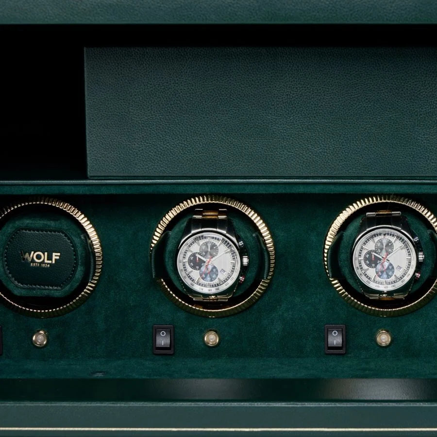 Green leather watch winder safe with four watch slots, three containing chronograph watches, gold accents, and control button