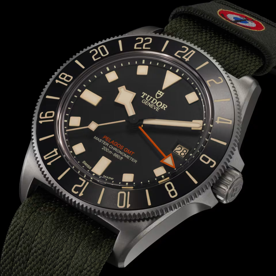 Tudor watch with black dial and green strap on a black background
