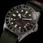 Tudor watch with black dial and green strap on a black background