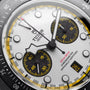 Chronograph watch face with white dial, black subdials with yellow markers, and yellow-accented bezel.