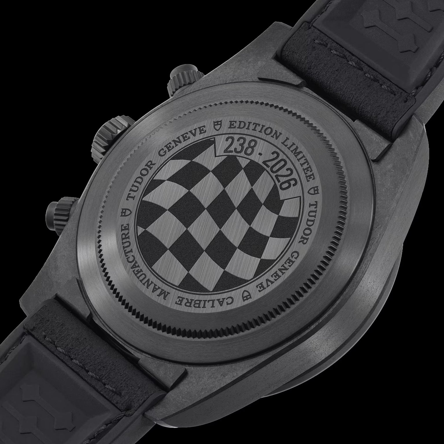 Black Bay Chrono Carbon watch with checkered dial, chronograph pushers, and black rubber strap shown from caseback view.