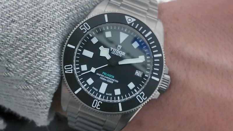 A Tudor Pelagos diver watch with a black dial and metal strap worn on a wrist.
